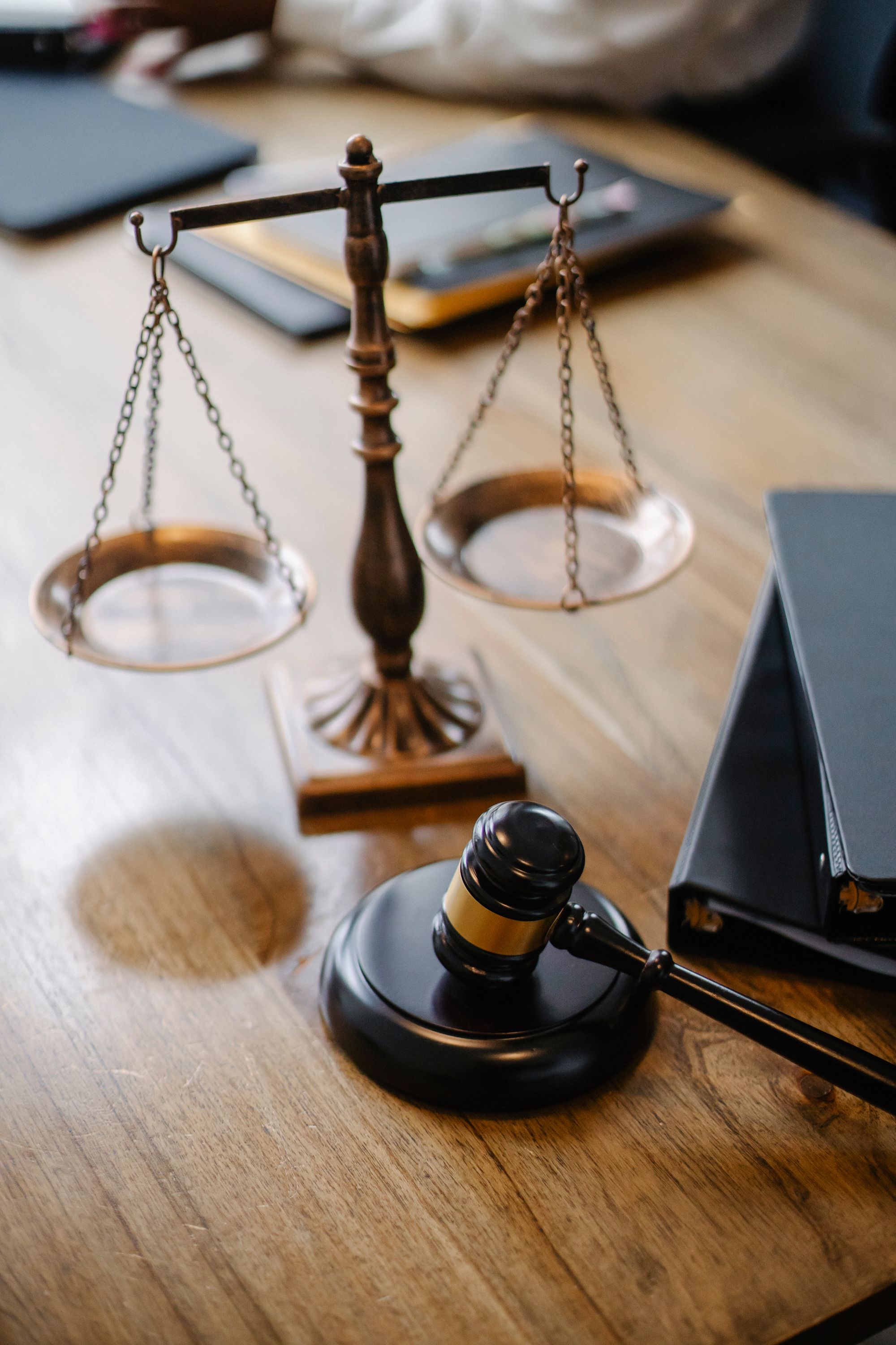 Balança da justiça e martelo sobre mesa de escritório
